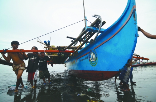 当地时间8月10日,马尼拉海域,漏油事故附近居民开始清理海滩上的油污